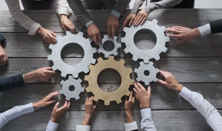 process image Hands carrying cogs coming together to streamline business processes.